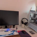 Bàn làm việc với setup PC chơi game hiện đại, màn hình tắt và không gian gọn gàng