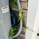 Cáp mạng CAT5e và cáp đồng trục cuộn lộn xộn bên ngoài tường gara nhà mới