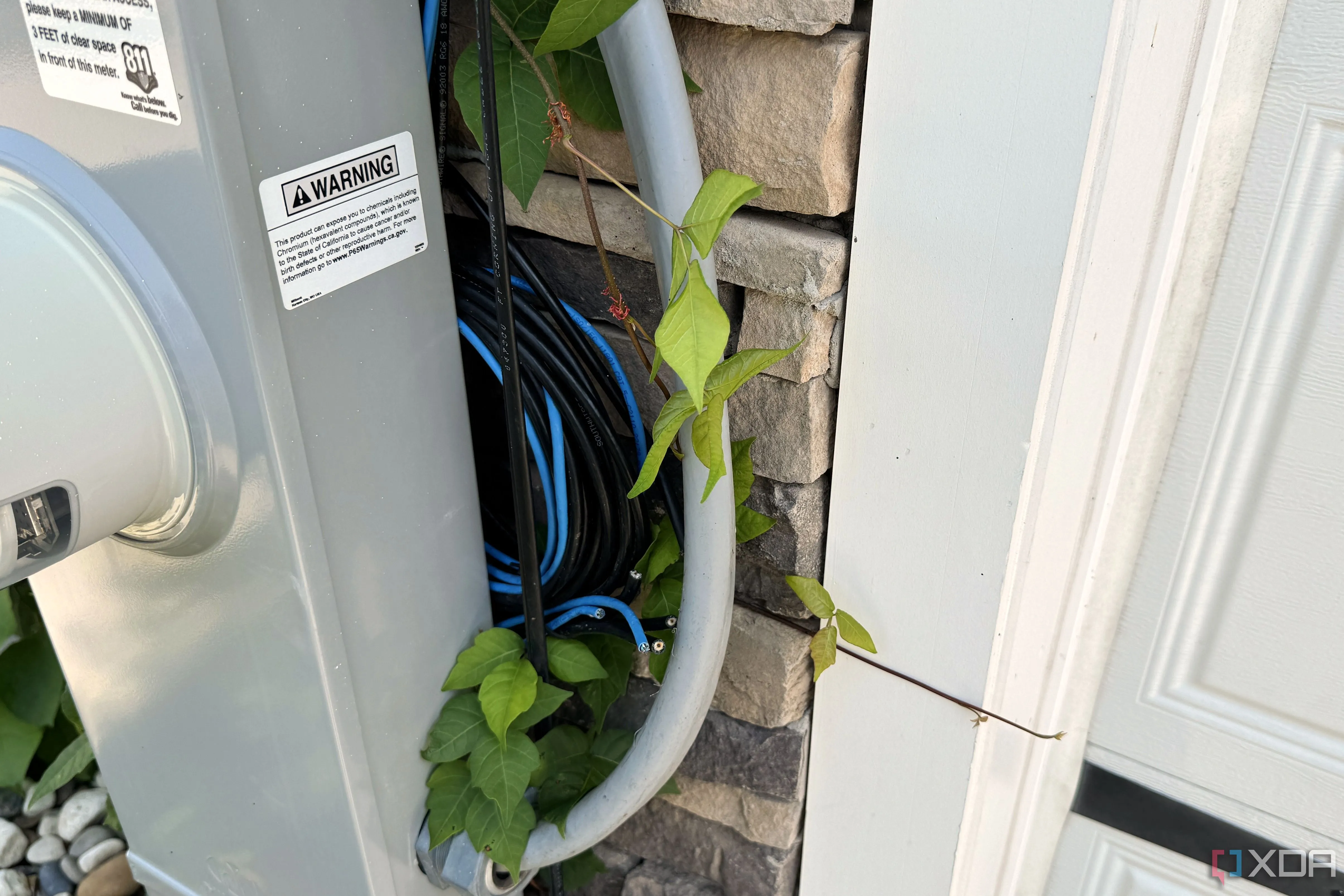 Cáp mạng CAT5e và cáp đồng trục cuộn lộn xộn bên ngoài tường gara nhà mới