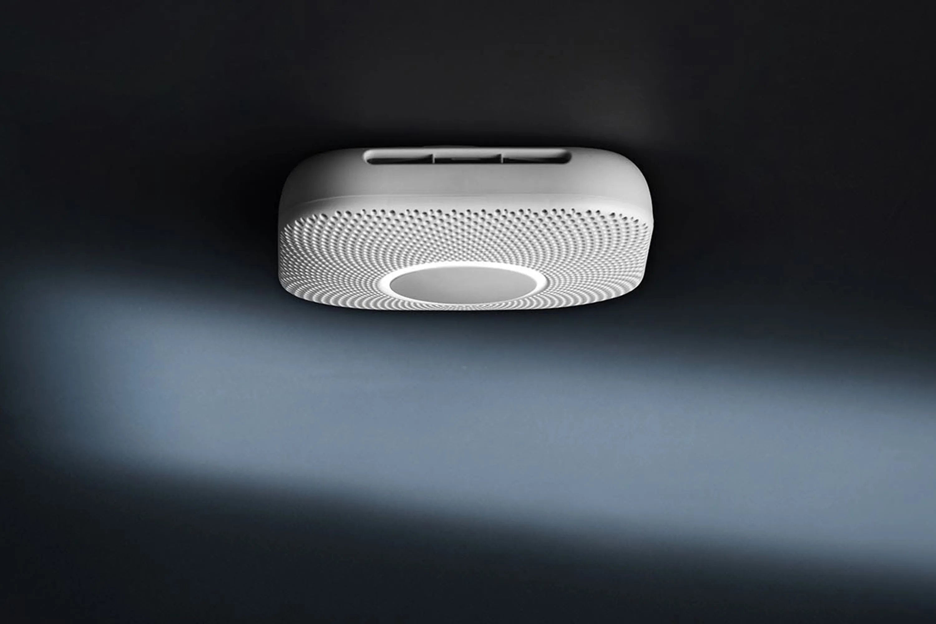 Đầu báo khói thông minh Google Nest với nút bấm tròn chính giữa và logo Google