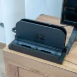 Đế sạc Nintendo Switch 2 với Dock Adapter dbrand Killswitch được lắp đặt, cho phép cắm máy có ốp lưng.