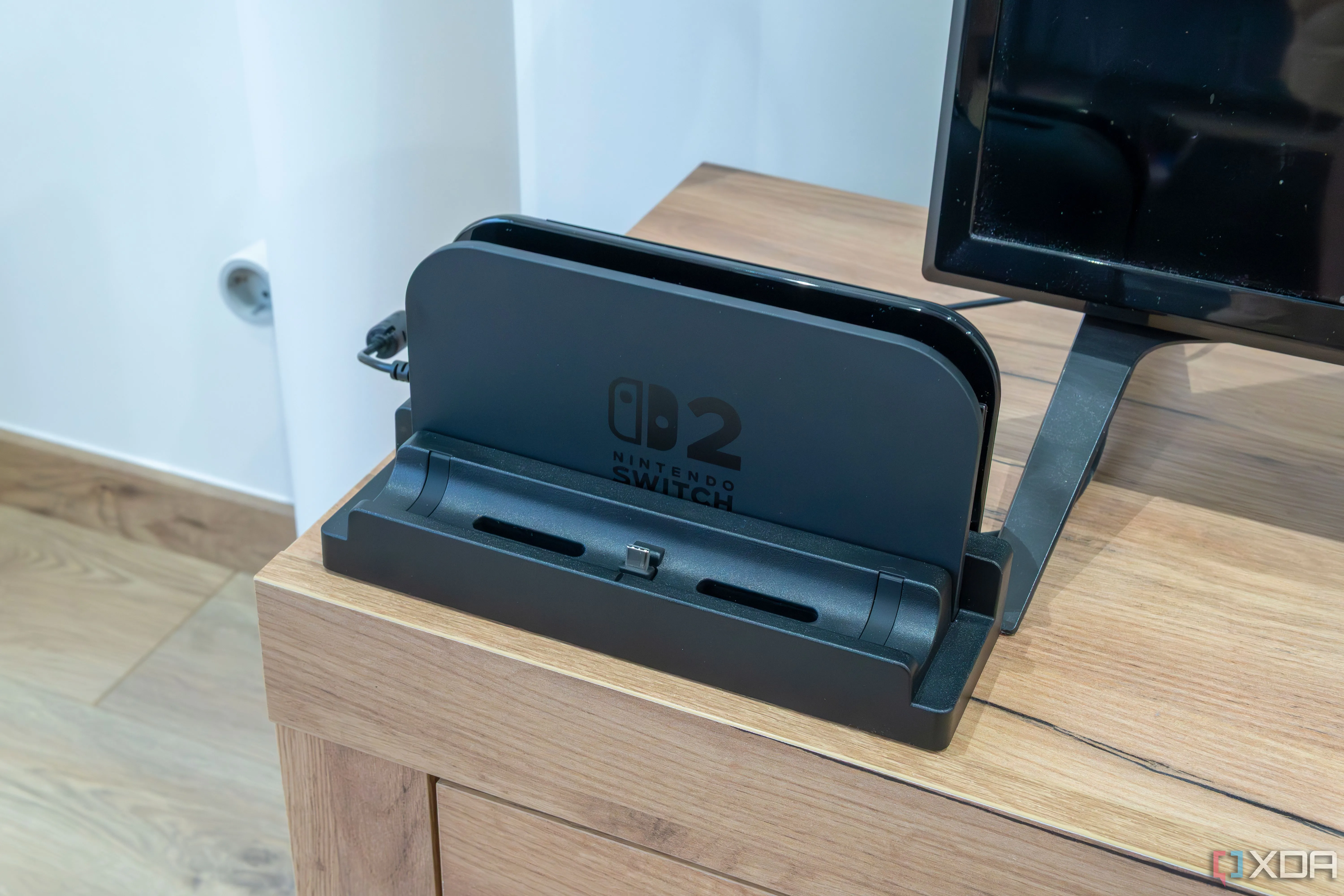 Đế sạc Nintendo Switch 2 với Dock Adapter dbrand Killswitch được lắp đặt, cho phép cắm máy có ốp lưng.