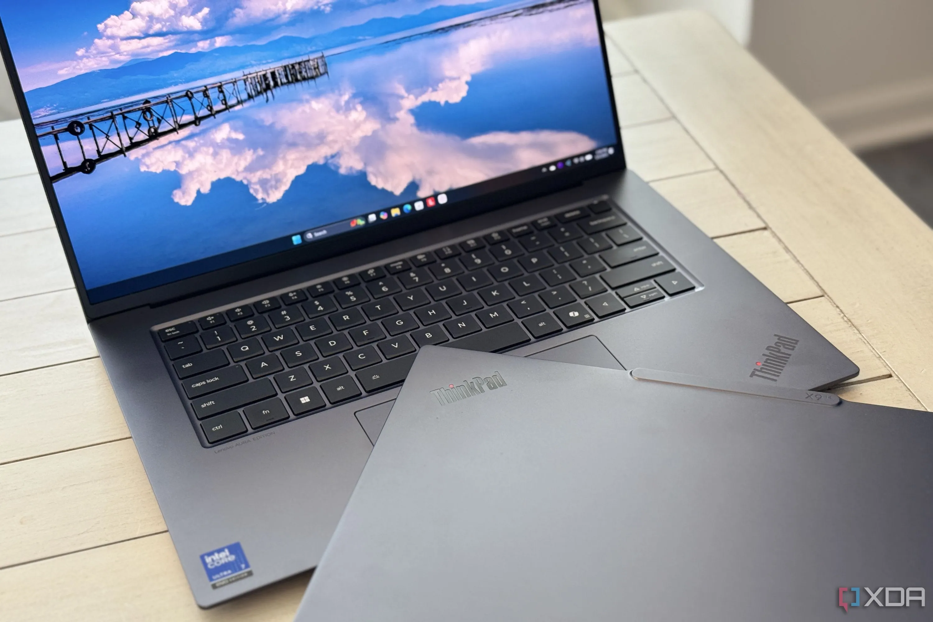 Hai chiếc laptop Lenovo ThinkPad X9 Aura Edition, một chiếc gập lại đặt trên bàn phím của chiếc còn lại