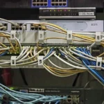 Hệ thống server và bộ chuyển mạch mạng với hàng loạt cáp Ethernet được sắp xếp gọn gàng bằng lược cáp, minh họa hiệu quả của giải pháp quản lý cáp cho trung tâm dữ liệu.