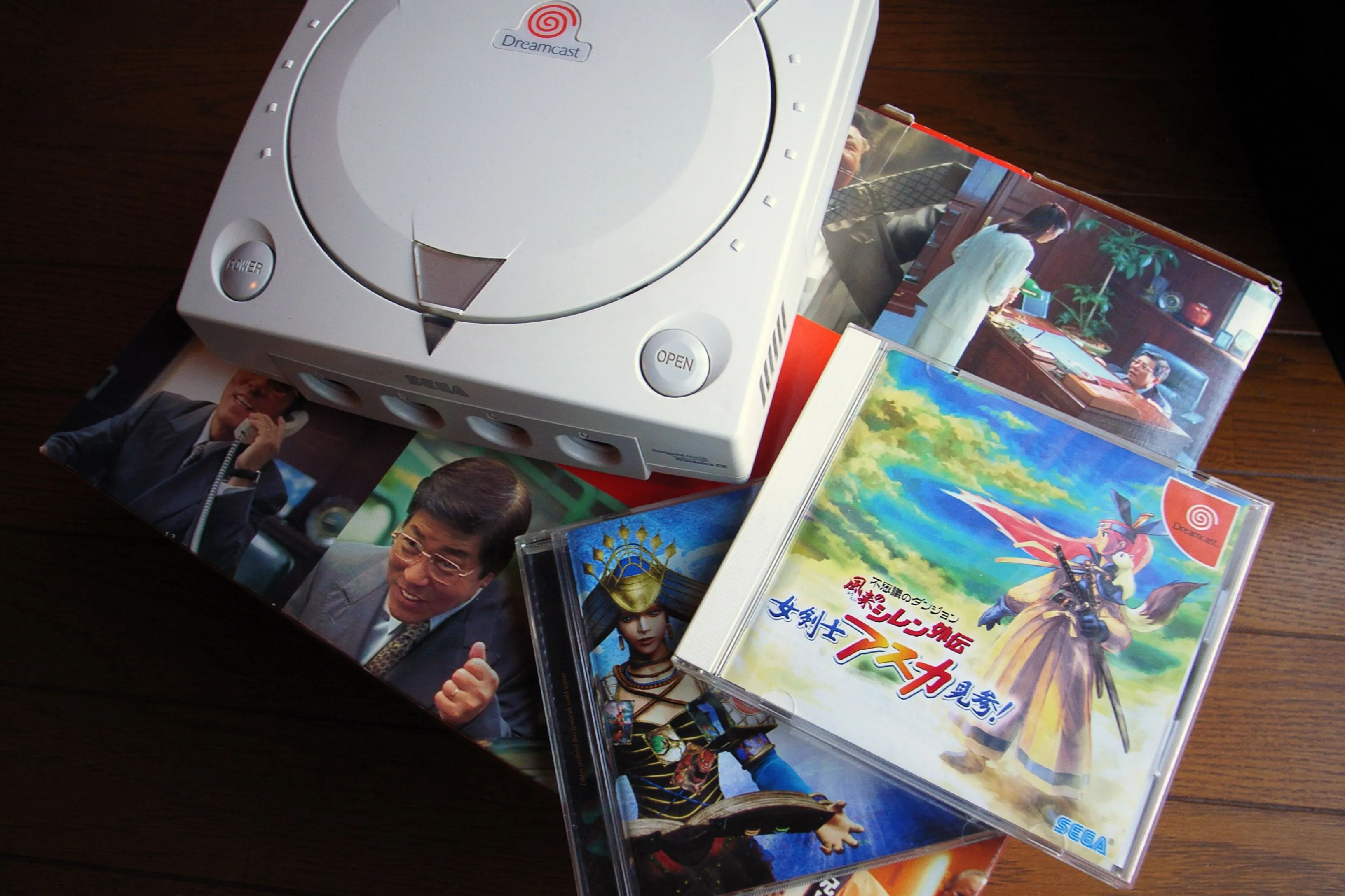 Hình ảnh máy console Sega Dreamcast màu trắng đặt cạnh các đĩa game, biểu tượng của một hệ máy tiên phong nhưng yểu mệnh.