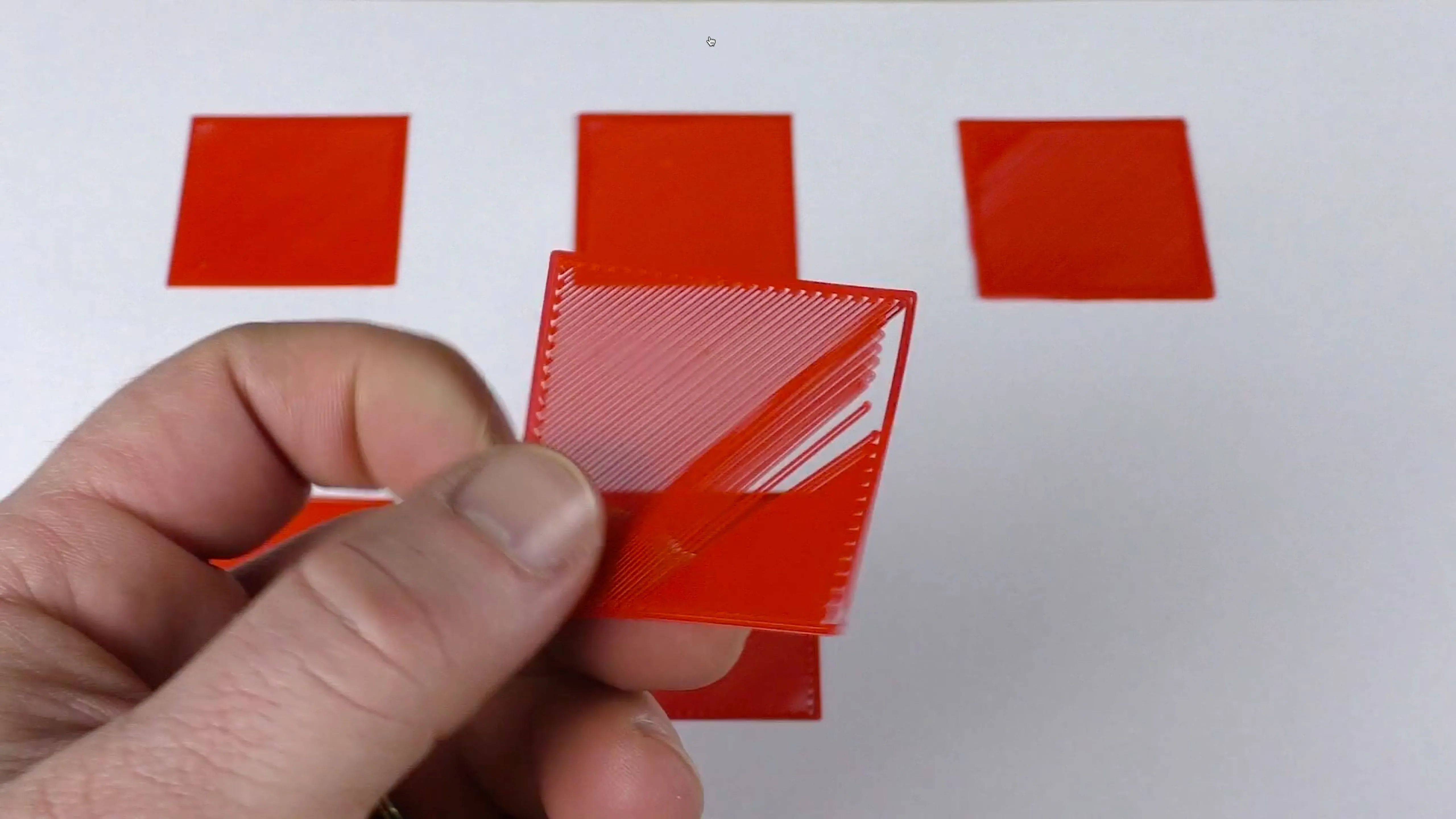 Hình vuông in thử trên bàn máy in 3D có khoảng trống giữa các đường, cho thấy vòi phun quá cao