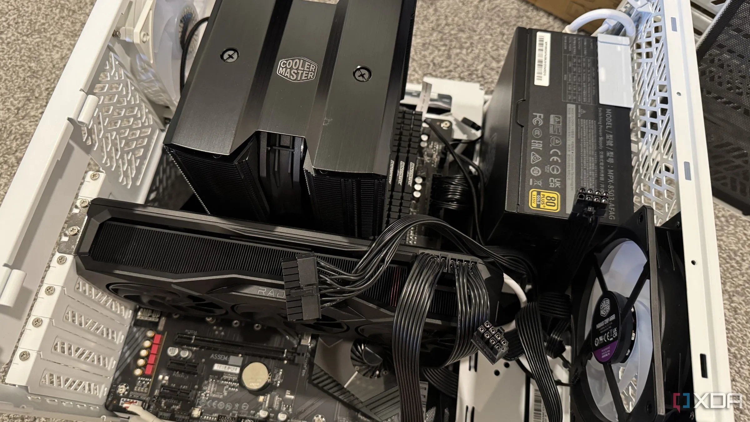 Lắp ráp PC với các dây cáp GPU đã cắm, cảnh báo về thách thức tản nhiệt trong thùng máy nhỏ