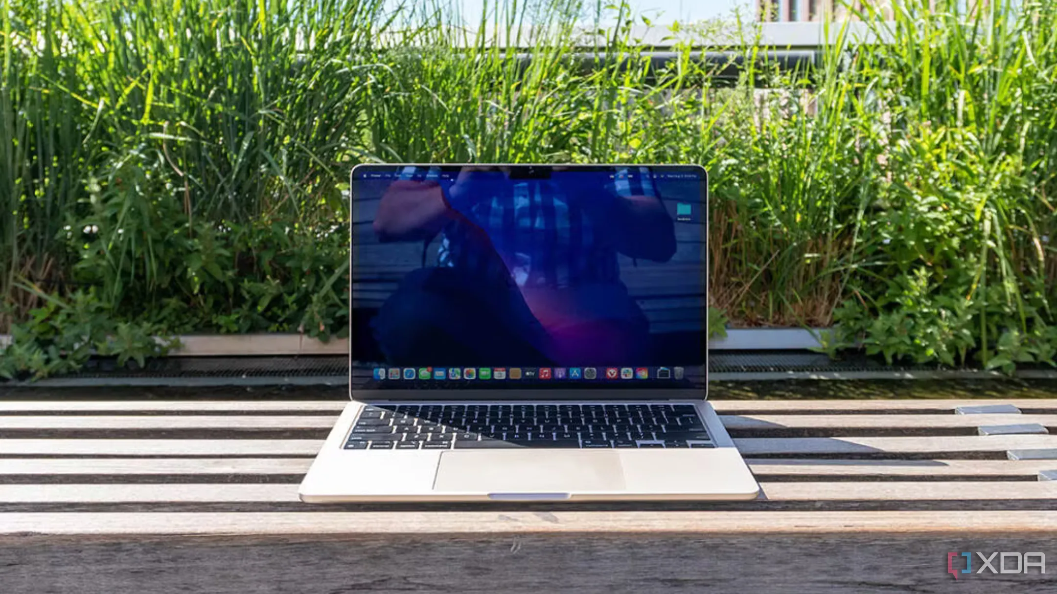 MacBook Air M2 màu bạc hiển thị màn hình Liquid Retina và bàn phím Magic Keyboard trên bàn làm việc