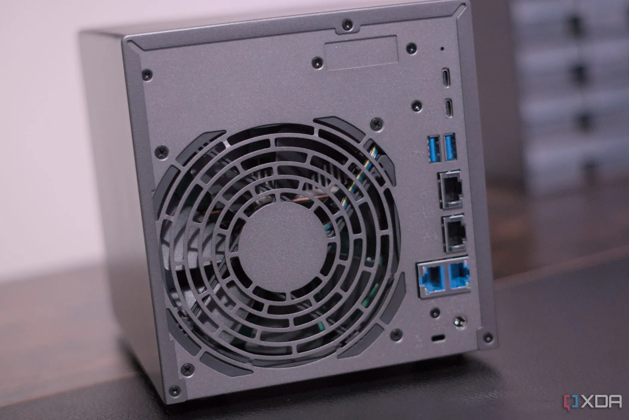 Mặt sau của thiết bị NAS Asustor AS6804T trên bàn làm việc, thể hiện các cổng kết nối