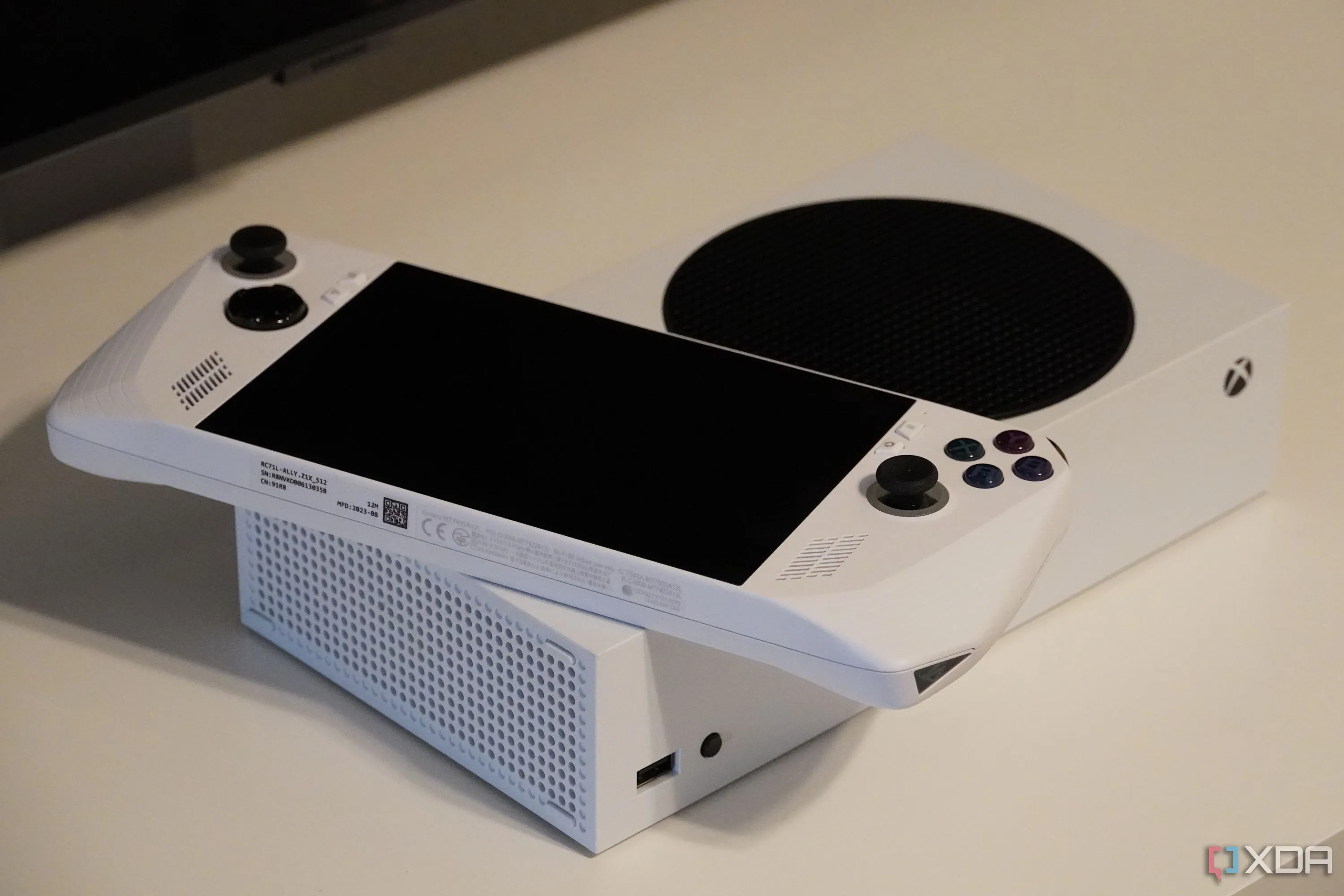 Máy chơi game cầm tay ROG Ally đặt trên console Xbox Series S, gợi mở về tương lai giao diện Xbox tùy chỉnh cho Windows handheld.