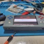 Một góc nhìn cận cảnh máy chơi game cầm tay tự chế với màn hình và các nút điều khiển