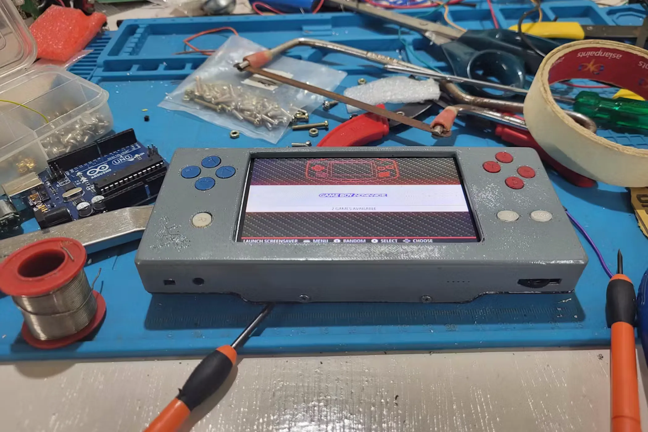 Một góc nhìn cận cảnh máy chơi game cầm tay tự chế với màn hình và các nút điều khiển