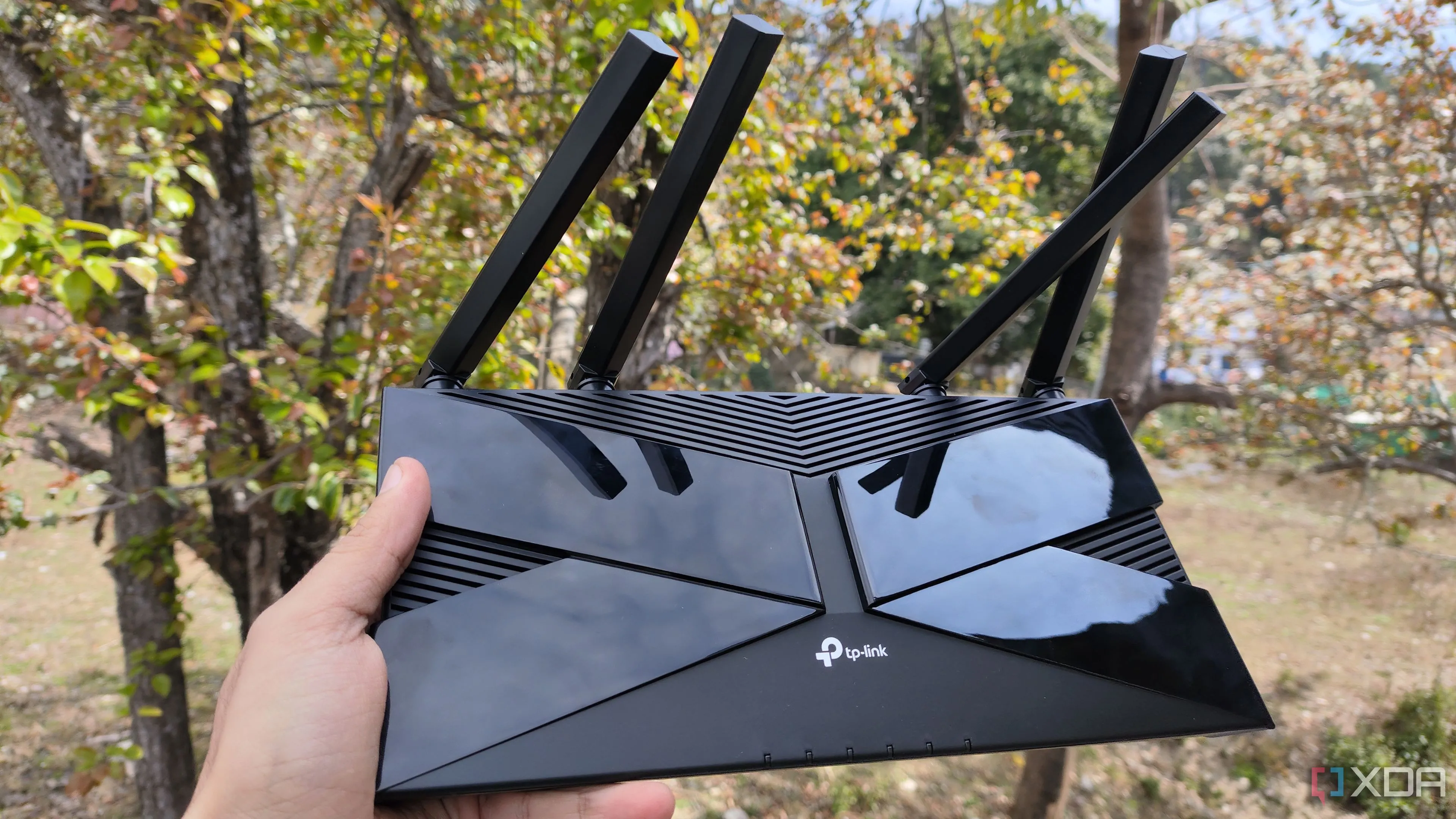 Một người đang cầm router TP-Link, minh họa thiết bị mạng có thể được giám sát bằng tích hợp SNMP trong Home Assistant.
