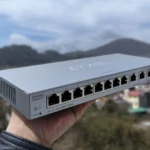 Một người đang cầm thiết bị chuyển mạch mạng Zyxel