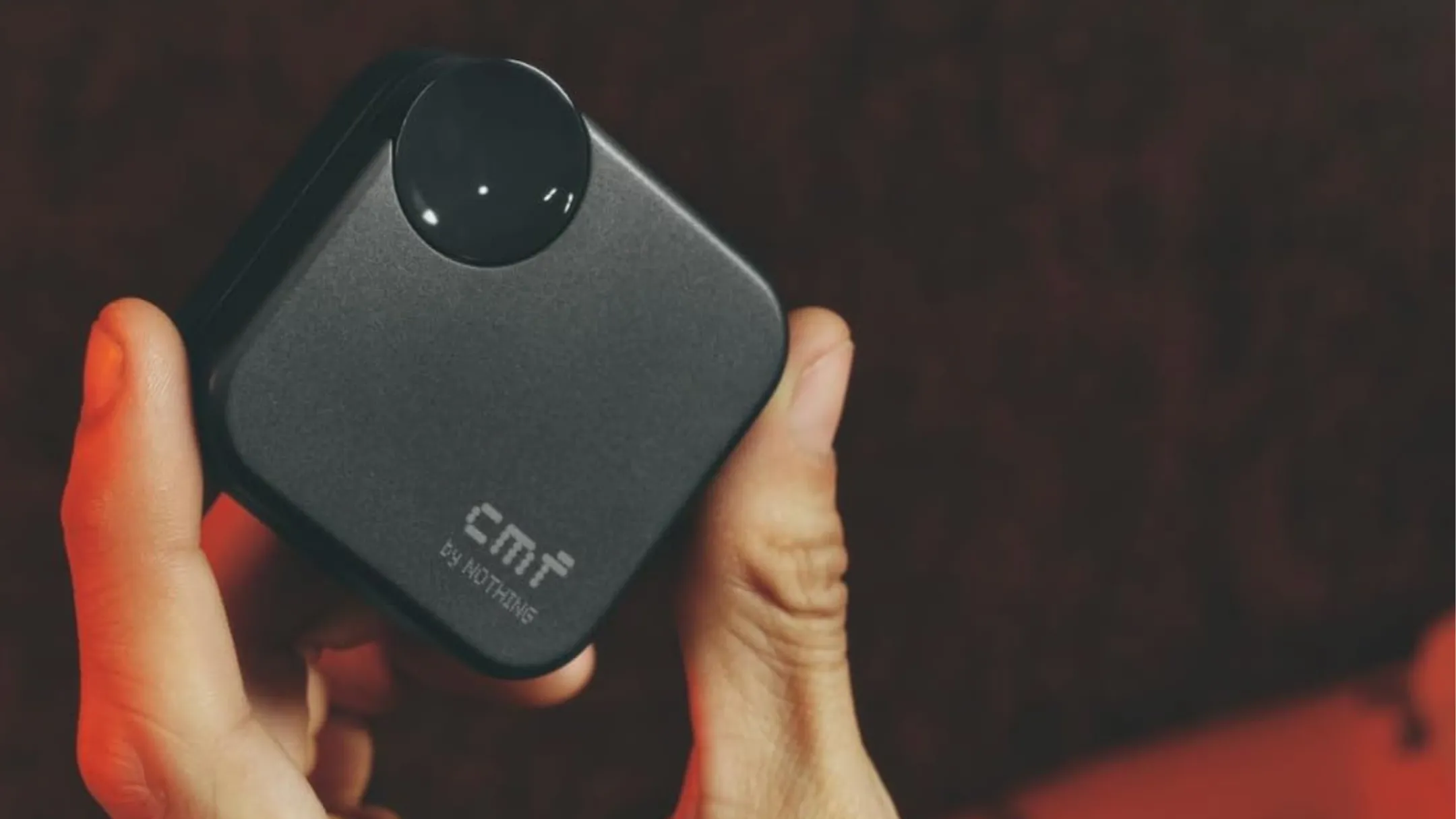 Người dùng cầm tai nghe không dây CMF Buds 2a màu vàng neon