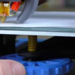 Người dùng đang thực hiện phương pháp cân bàn máy in 3D bằng giấy với đầu phun và tờ giấy