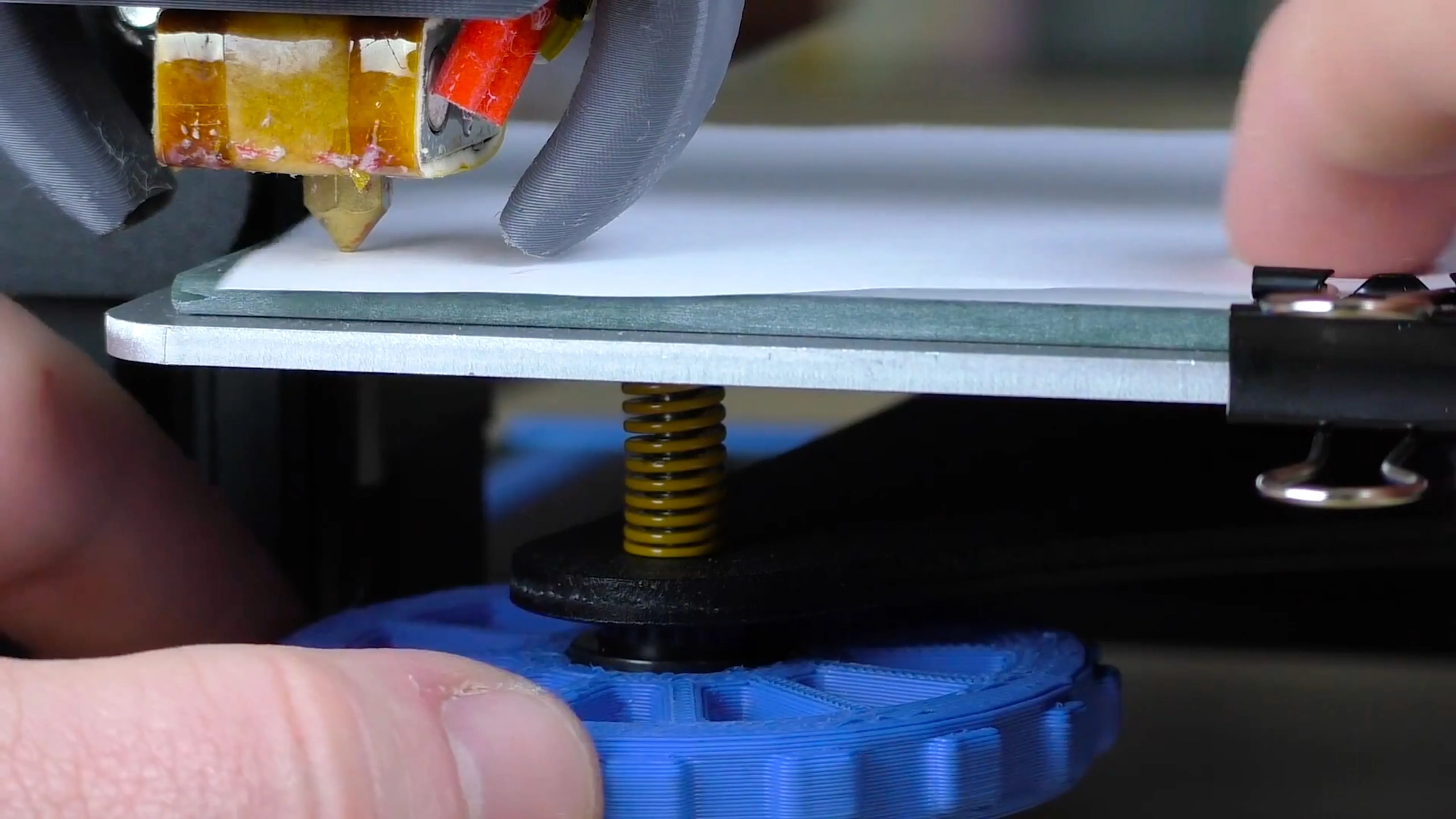 Người dùng đang thực hiện phương pháp cân bàn máy in 3D bằng giấy với đầu phun và tờ giấy