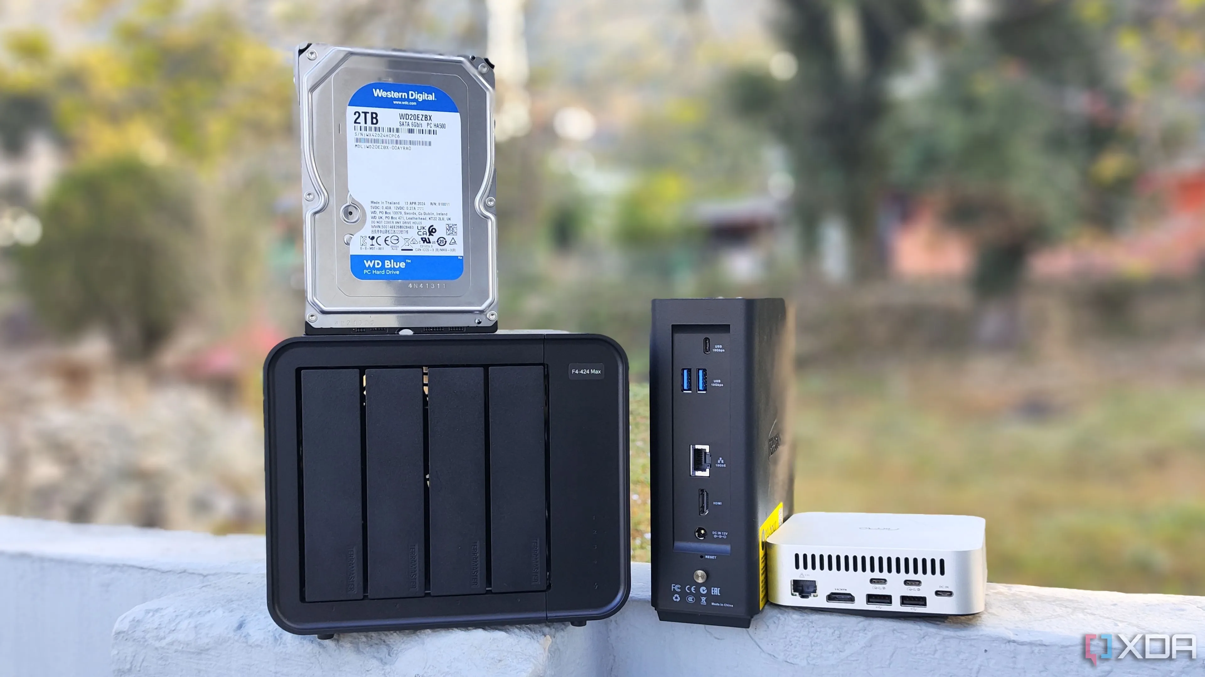 Nhiều thiết bị NAS khác nhau như TerraMaster F4-424 Max và Aiffro K100, minh họa các công cụ bảo mật tích hợp sẵn trên các mẫu NAS hiện đại