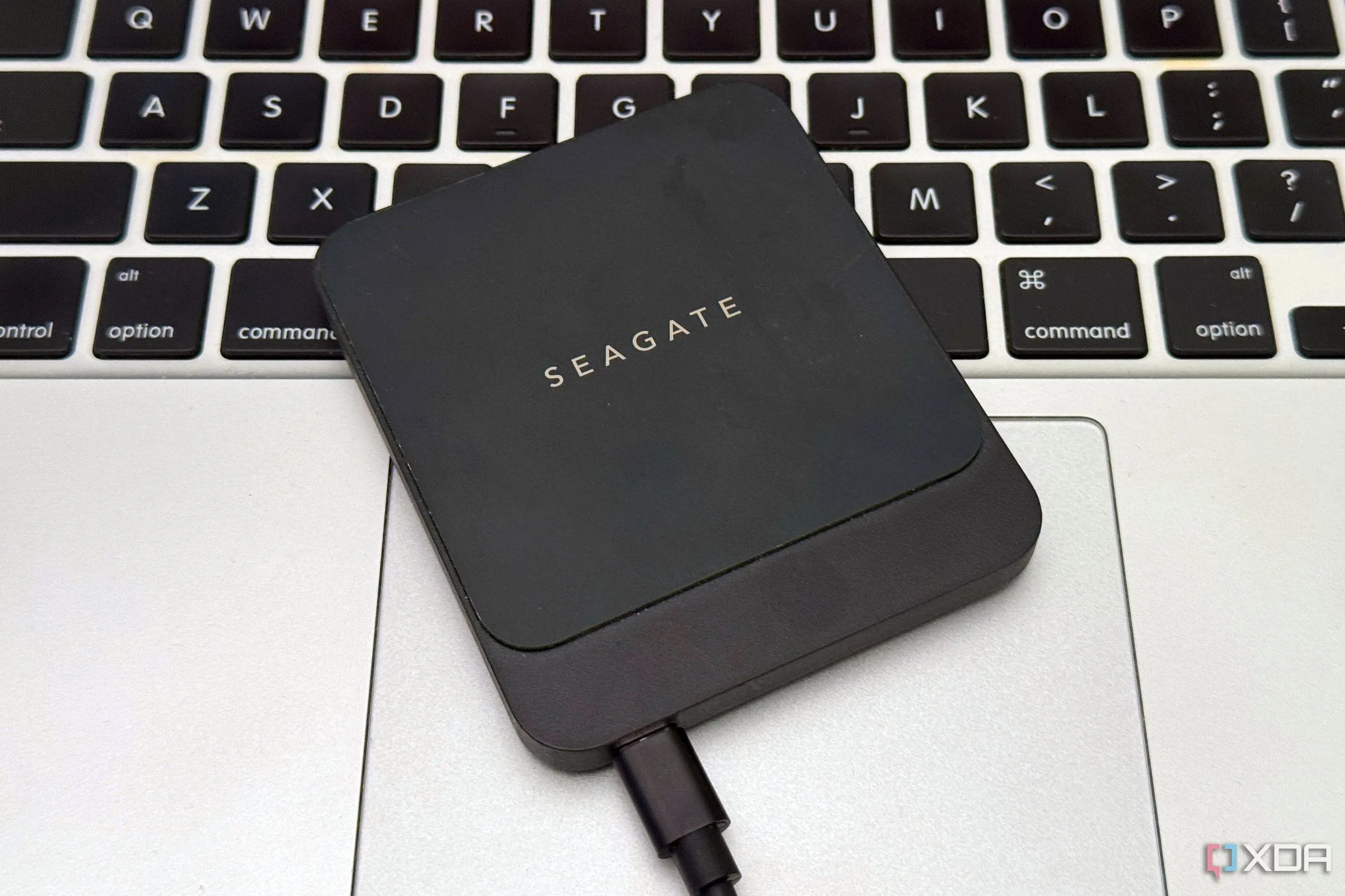 Ổ cứng SSD di động nhỏ gọn đặt cạnh laptop, minh họa cách bổ sung dung lượng lưu trữ ngoài cho PC.