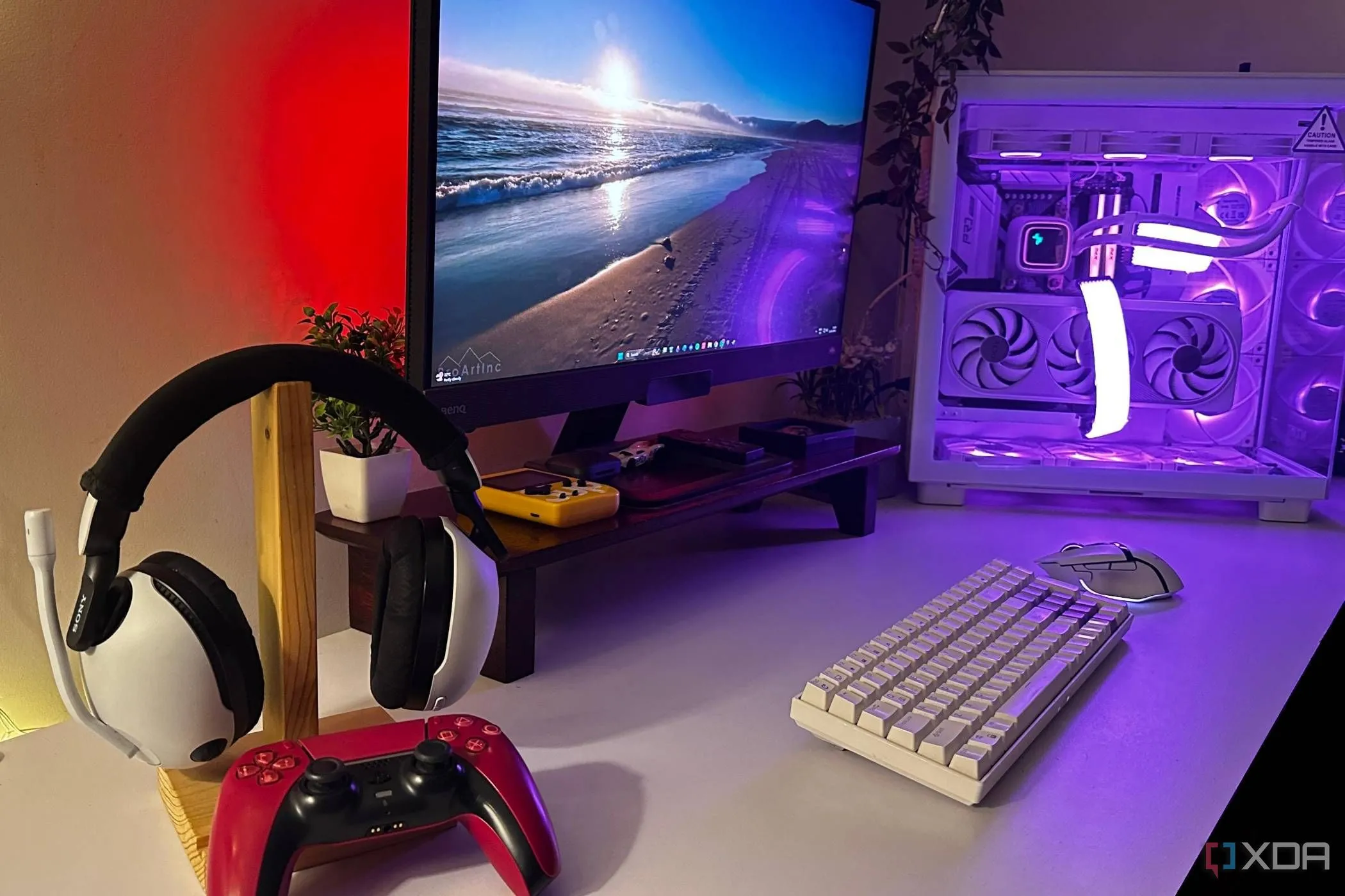 Tai nghe Sony Inzone và tay cầm DualSense PS5 màu đỏ trên bàn cùng PC gaming