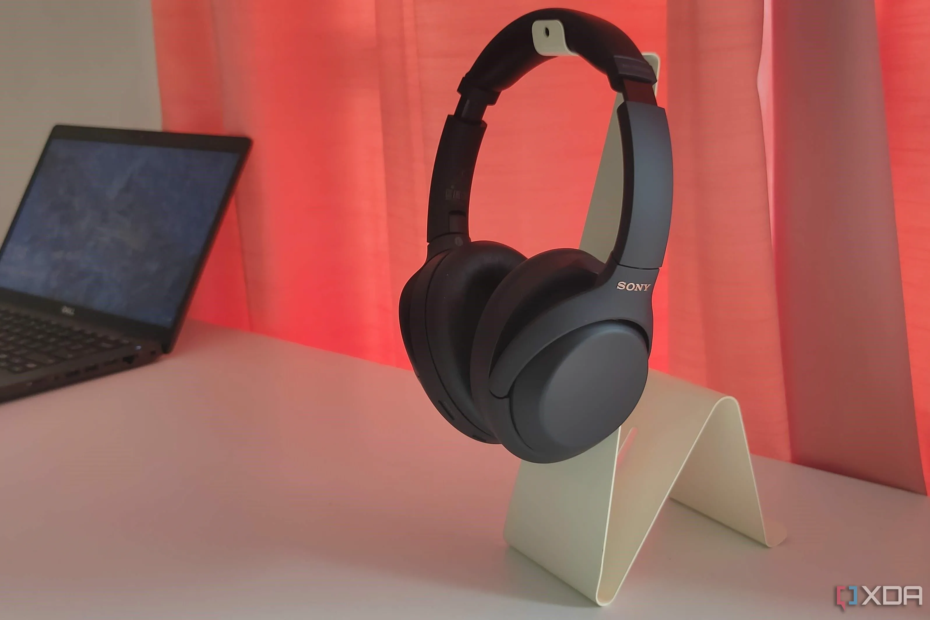 Tai nghe Sony WH-1000XM4 màu đen đặt trên giá đỡ màu trắng