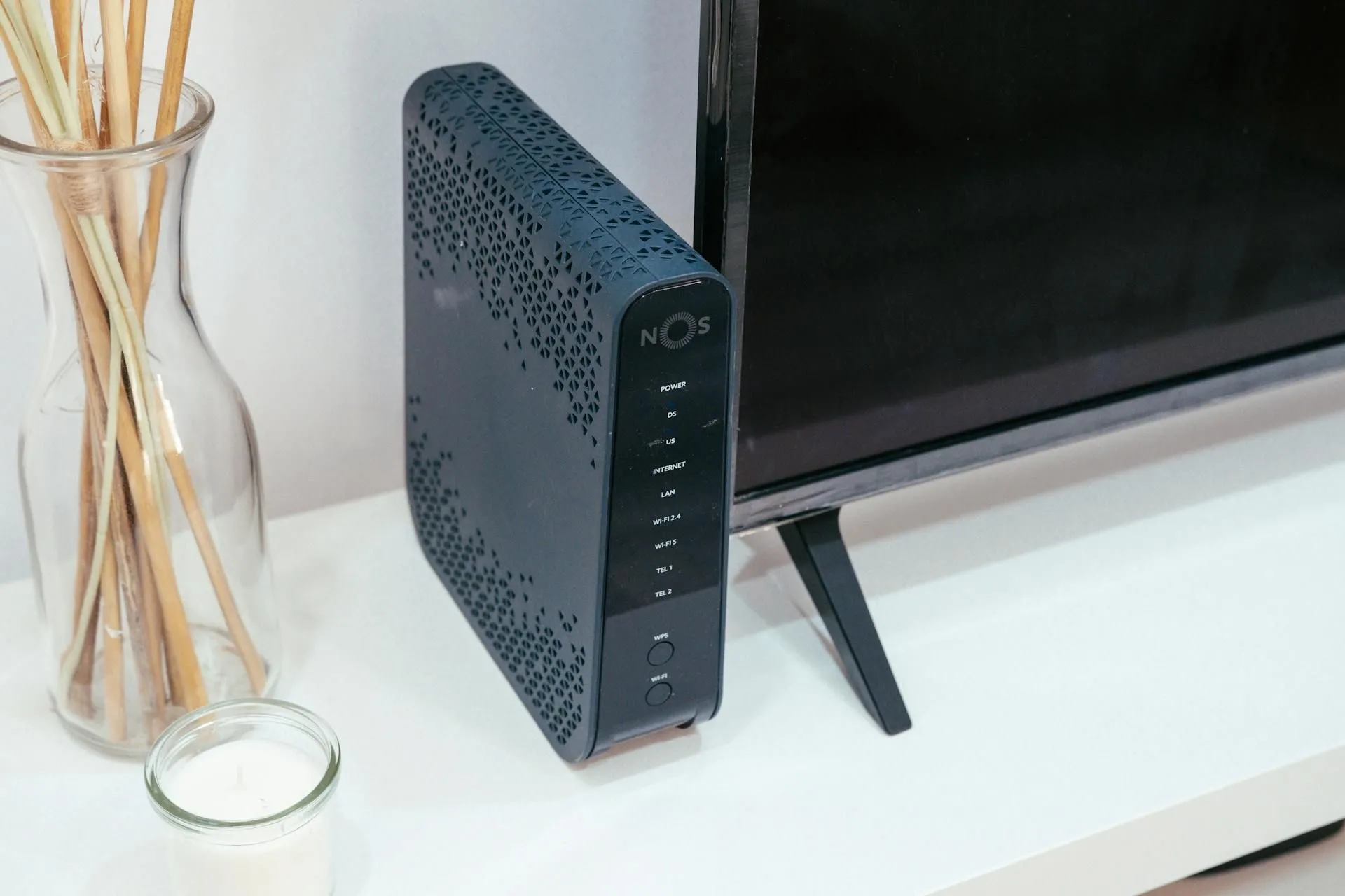 Thiết bị router WiFi hiện đại đặt cạnh tivi và lư hương, tượng trưng cho trung tâm kết nối mạng gia đình.
